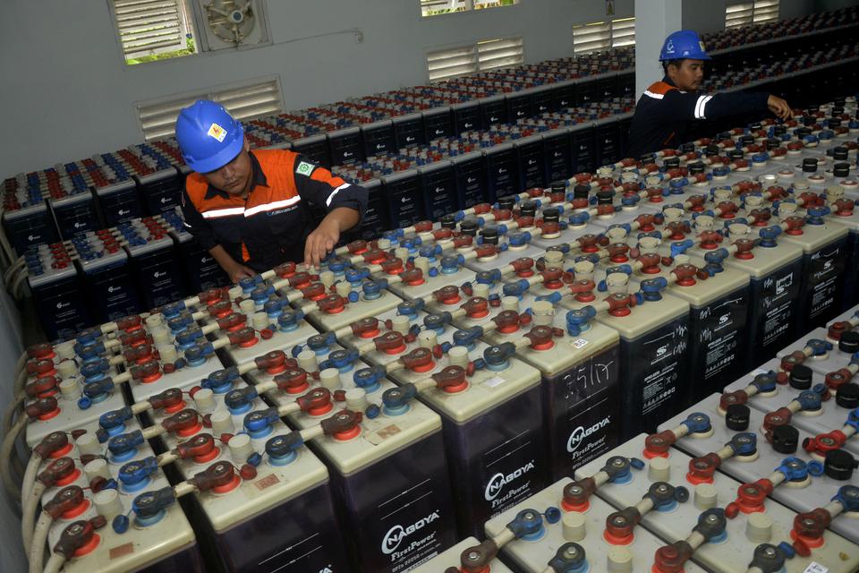 Dua pekerja memeriksa baterai panel Pembangkit Listrik Tenaga Surya (PLTS) di Pulau Kodingareng, Kecamatan Sangkarrang, Makassar, Sulawesi Selatan, Kamis (15/12/2022). Baterai panel surya merupakan komponen Pembangkit Listrik Tenaga Surya untuk menyimpan 