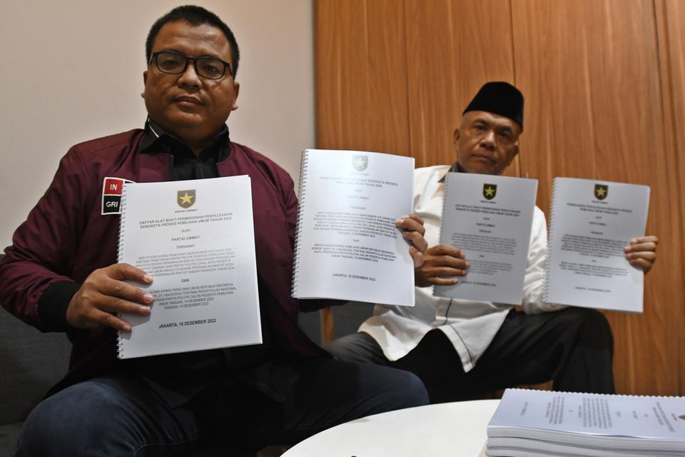 Ketua Tim Advokasi Hukum Partai Ummat Denny Indrayana (kiri) dan Wakil Ketua Tim Advokasi Hukum Partai Ummat Herman Kadir (kanan) menunjukkan berkas permohonan penyelesaian sengketa proses Pemilu 2024 ke petugas Bawaslu di Jakarta, Jumat (16/12/2022). Par