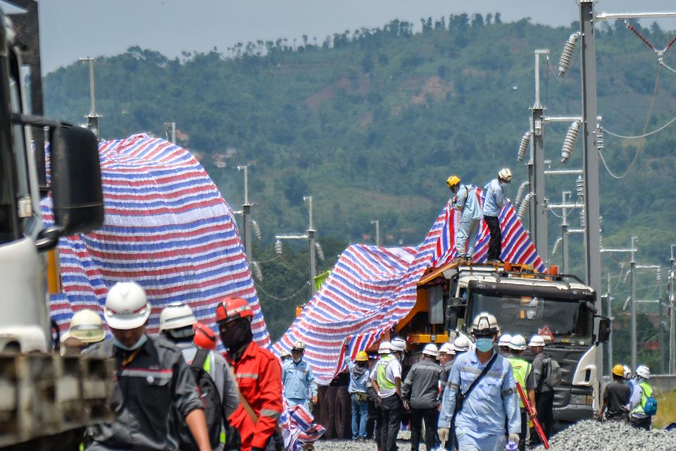 Pekerja menutupi bangkai kereta teknis yang mengalami kecelakaan menggunakan kain di Campaka Mekar, Kabupaten Bandung Barat, Jawa Barat, Senin (19/12/2022). Kadiv Humas Polri Irjen Pol Dedi Prasetyo menyatakan, kecelakaan kereta teknis pada proyek Kereta 