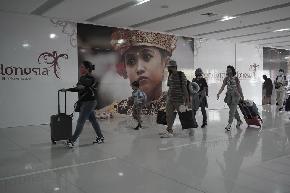 Sejumlah penumpang pesawat berjalan di bandara internasional Ngurah Rai, Badung, Bali, Rabu (21/12/2022). 