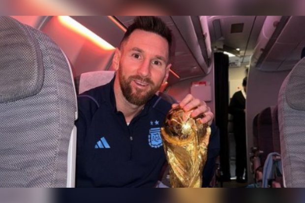 Lionel Messi berpose dengan trofi Piala Dunia