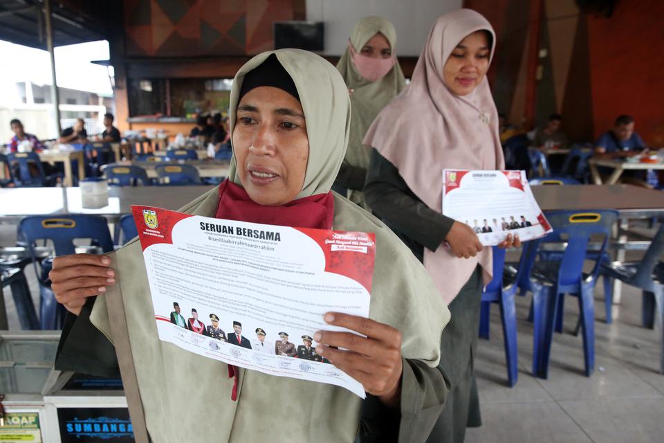 Personel Wilayatul Hisbah (Polisi Syariat Islam) Kota Banda Aceh mensosialisasikan dan membagikan seruan bersama Forum Komunikasi Pimpinan Daerah (Forkopimda) tentang larangan perayaan pergantian malam tahun Masehi 2023 di Banda Aceh, Aceh, Kamis (29/12/2