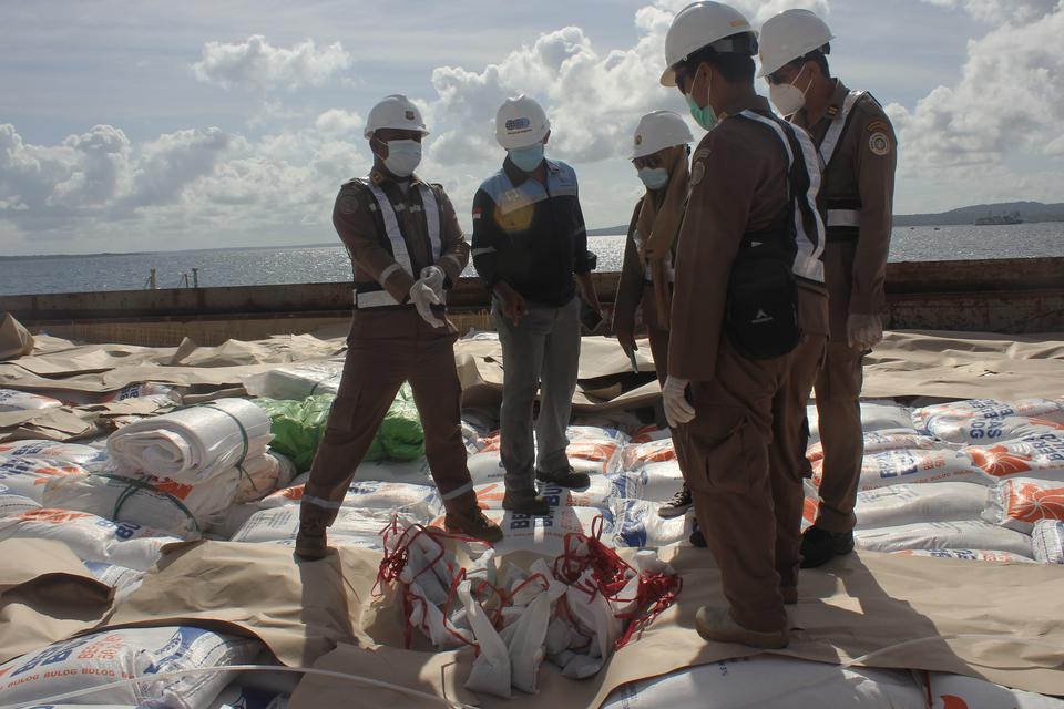 Sejumlah petugas dari Balai Karantina Pertanian Kelas I Kupang mengecek karung berisi beras impor asal Vietnam di atas kapal MV Hoang Trieu 69 yang tiba di Pelabuhan Tenau Kupang, NTT, Jumat (13/01/2023). Perum Bulog NTT mendapatkan kiriman lima ribu ton 
