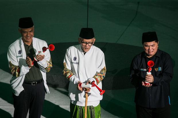 Menteri BUMN Erick Thohir (kanan), Rais Aam PBNU Kiai Miftachul Akhyar (tengah), dan Gubernur Jawa Tengah Ganjar Pranowo (kiri) membunyikan terompet saat pembukaan Porseni NU di GOR Sritex Arena, Solo, Jawa Tengah, Senin (16/1/2023). Porseni Nahdlatul Ula
