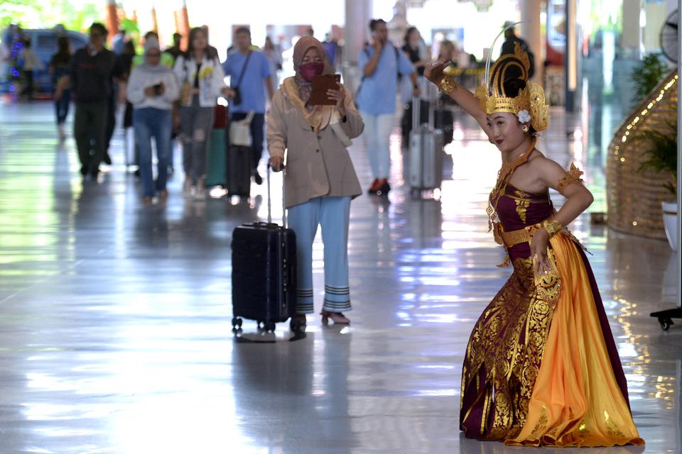 Penari menampilkan tarian Bali untuk menghibur penumpang pesawat yang tiba di Terminal Domestik Bandara Internasional I Gusti Ngurah Rai, Badung, Bali, Jumat (20/1/2023).