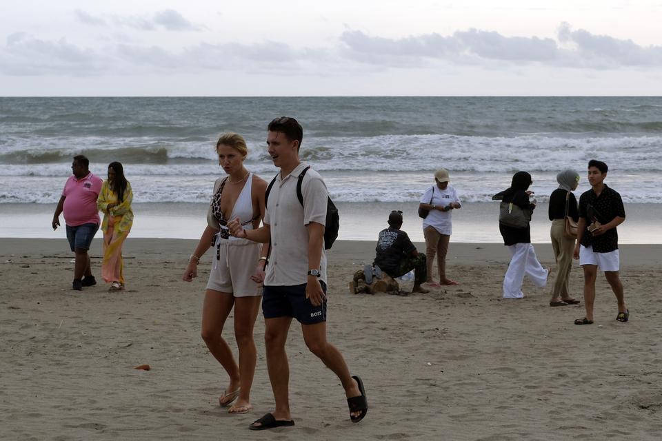 Wisatawan mengunjungi objek wisata Pantai Petitenget di Kuta Utara, Badung, Bali, Rabu (1/2/2023). Badan Pusat Statistik mendata selama tahun 2022 jumlah kunjungan wisman ke Indonesia mencapai 5,47 juta kunjungan atau meningkat 251,28 persen dibandingkan 
