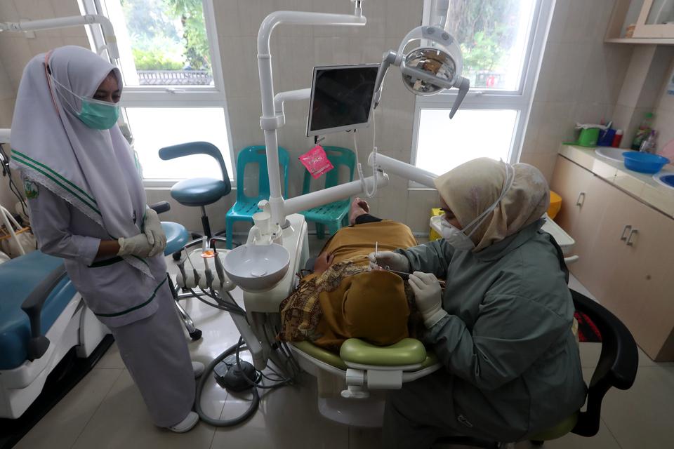 Dokter ahli memeriksa gigi dan mulut pasien di pusat kesehatan masyarakat (Puskesmas) Ulee Kareng, Banda Aceh, Aceh, Kamis (2/2/2023). 