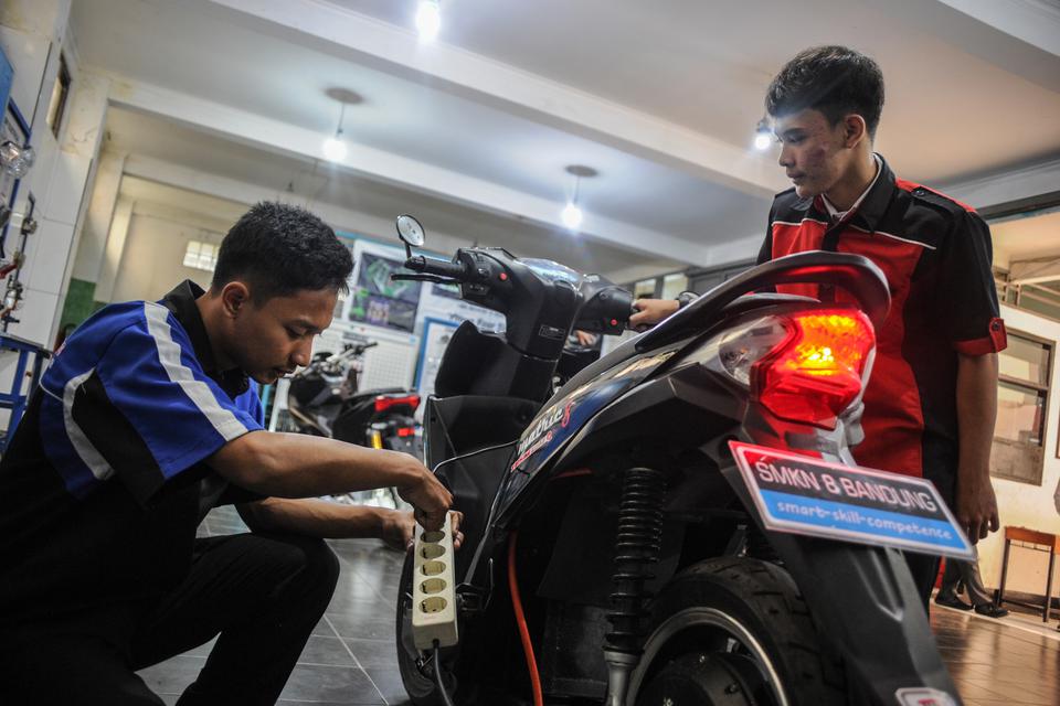 Siswa SMK melakukan perawatan motor berbahan bakar minyak yang telah dikonversikan ke listrik di SMKN 8 Bandung, Jawa Barat, Jumat (10/2/2023). 