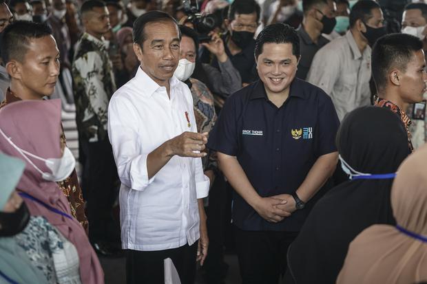 Presiden Joko Widodo (kiri) didampingi Menteri BUMN Erick Thohir (kanan) berbincang dengan warga penerima Kredit Usaha Rakyat (KUR) pada acara Penyerahan KUR 2023 dan Peluncuran Kartu Tani Digital untuk Pupuk Bersubsidi di Lhokseumawe, Aceh, Jumat (10/2/2