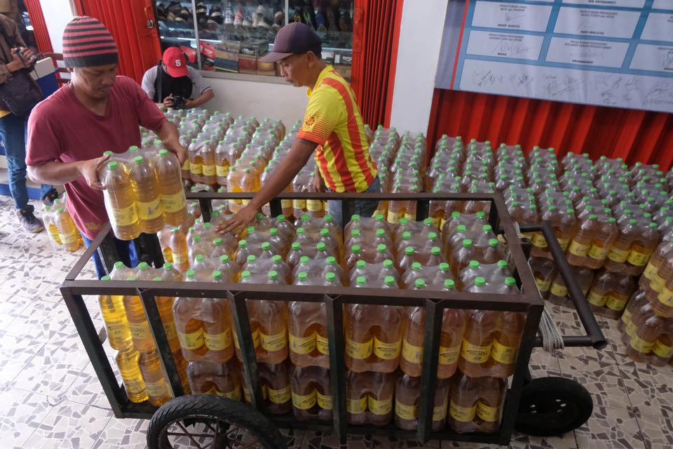 Pekerja menata minyak goreng "Minyakita" di atas gerobak di Pasar Kliwon, Temanggung, Jawa Tengah, Senin (20/2/2023). 