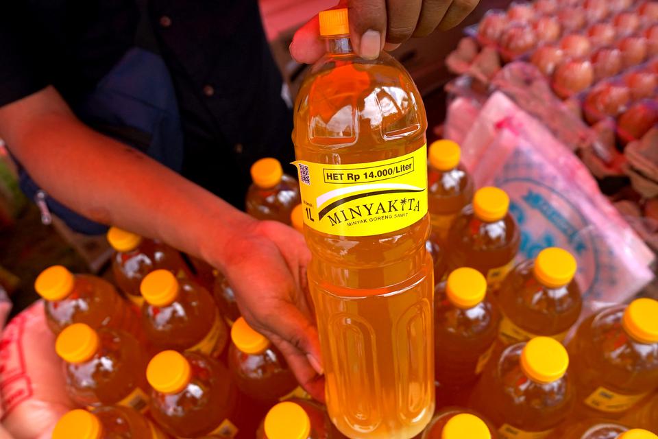 Seorang staf menunjukkan minyak goreng Minyakita kepada pembeli pada Pasar Murah Pangan di Liluwo, Kota Gorontalo, Gorontalo, Selasa (21/2/2023). Pemerintah Provinsi Gorontalo, Bulog Subdivre Gorontalo dan Kantor Perwakilan Bank Indonesia Gorontalo mengge