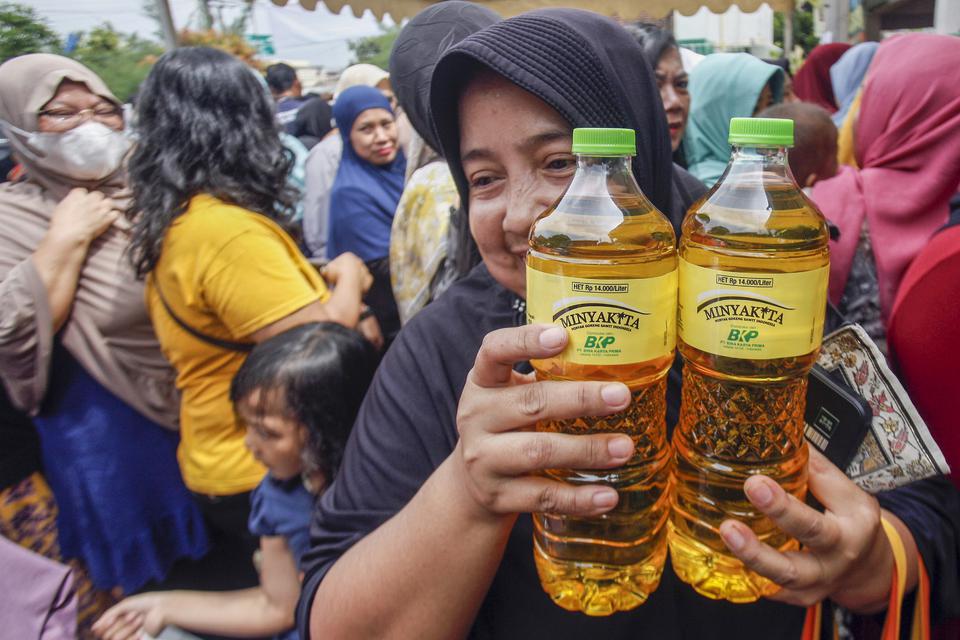 Warga menunjukkan minyak goreng Minyakita yang dibelinyaa saat gerakan pangan murah di Karadenan, Kabupaten Bogor, Jawa Barat, Kamis (23/2/2023). Gerakan pangan murah yang diselenggarakan Dinas Ketahanan Pangan Kabupaten Bogor tersebut untuk stabilisasi p