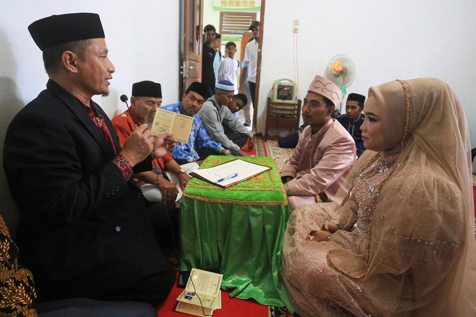 Penghulu membimbing pasangan pengantin yang melaksanakan akad nikah di Kantor Urusan Agama (KUA) Ulee Kareng, Banda Aceh, Aceh, Kamis (23/2/2023). Pemerintah menetapkan pasangan yang menikah di KUA tidak dipungut biaya dan jika menikah di luar KUA dikenak