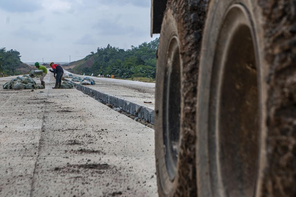 Pekerja menyelesaikan proyek pembangunan jalan tol Rangkasbitung-Panimbang seksi II di Lebak, Banten, Minggu (26/2/2023). Proyek pembangunan jalan tol Serang-Panimbang sepanjang 83,7 kilometer dengan nilai investasi Rp8,58 triliun ditargetkan dapat berope