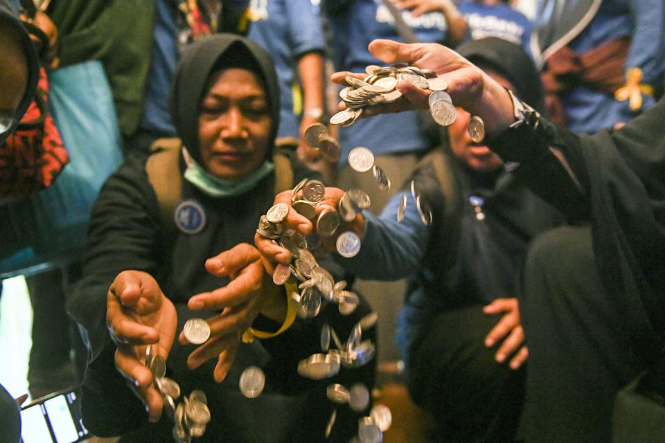 Sejumlah pemegang polis Asuransi Jiwa Bersama (AJB) Bumiputera 1912 mengumpulkan uang koin saat melakukan aksi di Wisma Bumiputera, Jakarta, Selasa (28/2/2023).