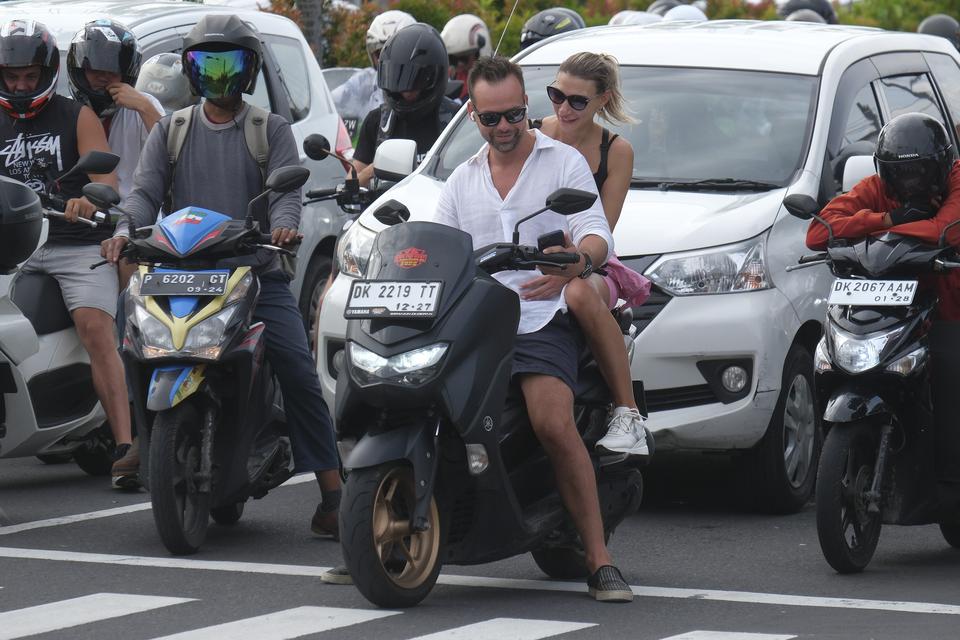 Sejumlah turis asing mengendarai sepeda motor tanpa mengenakan helm di Jalan Sunset Road, Kuta, Badung, Bali, Selasa (28/2/2023). 