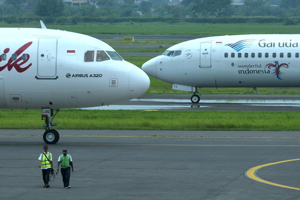 Petugas berjalan di dekat pesawat udara di Bandara Internasional Juanda Surabaya di Sidoarjo, Jawa Timur, Sabtu (4/3/2023). 