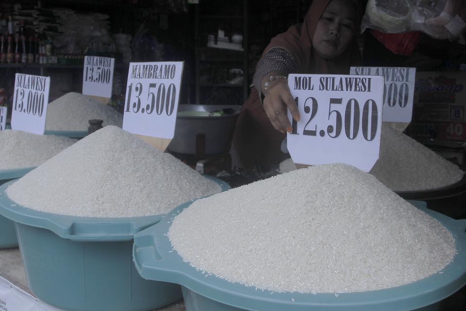 Seorang pedagang meletakkan papan harga beras di Pasar Naikoten, Kota Kupang, NTT, Jumat (10/3/2023). 