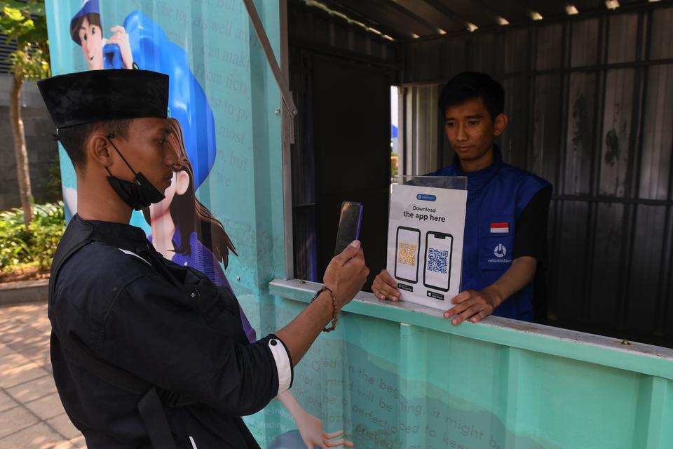 Petugas melayani warga memindai kode batang aplikasi penukaran sampah anorganik menjadi poin uang elektronik di tempat penukaran Rekosistem di Stasiun MRT Dukuh Atas, Jakarta, Jumat (10/3/2023). Tempat tersebut menerima sampah anorganik dari masyarakat be
