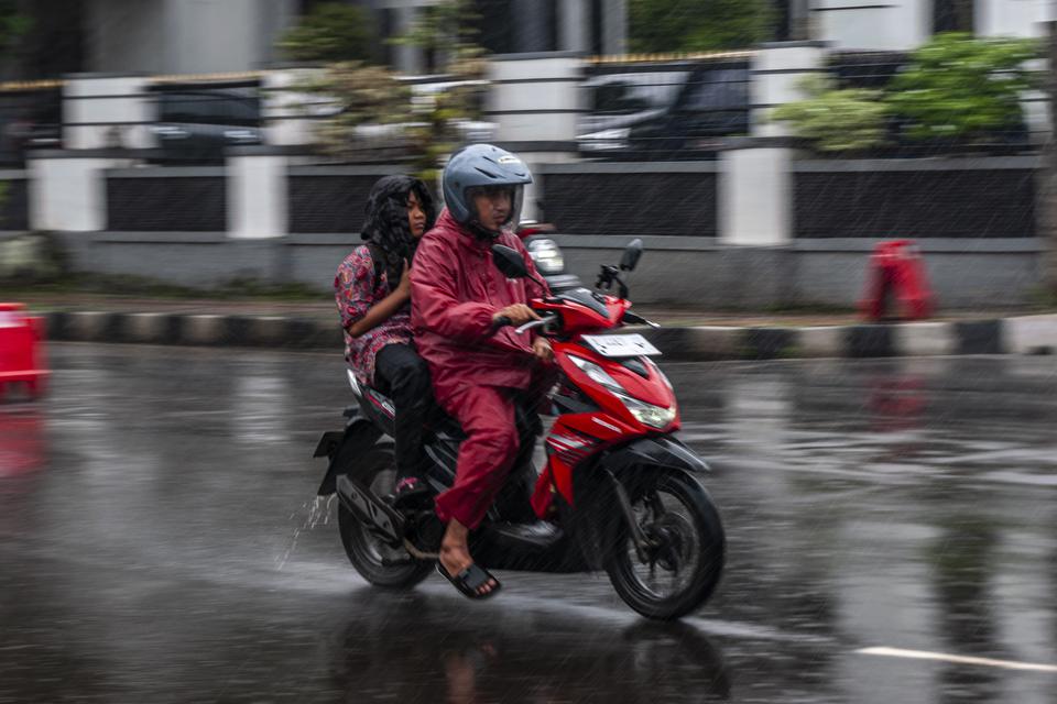 Pengendara roda dua menerobos hujan di Pandeglang, Banten, Senin (13/3/2023). Badan Meteorologi, Klimatologi dan Geofisika (BMKG) mengingatkan sejumlah wilayah Indonesia berpotensi mengalami hujan lebat yakni lebih dari 50 milimeter pada hari Senin (13/3)
