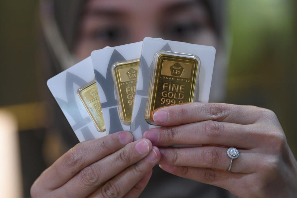 Petugas menunjukkan emas Antam di Butik Antam Pulo Gadung, Jakarta, Selasa (14/3/2023). Harga emas PT Aneka Tambang (Antam) Tbk. mengalami kenaikan menjadi Rp1,064 juta per gram pada Selasa (14/3) dari harga Senin (13/3) Rp1,054 juta per gram dan harga ak
