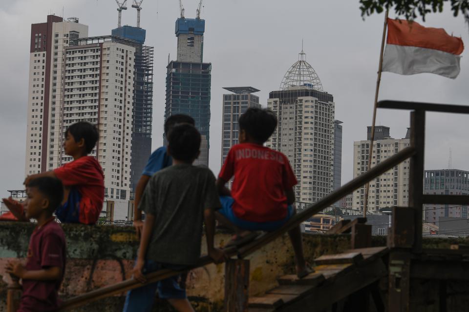 Sejumlah anak bermain dengan berlatar belakang gedung-gedung bertingkat di Jakarta, Selasa (14/3/2023). Utang luar negeri alias ULN Indonesia pada Februari 2023 sebesar Rp 6.097 triliun.