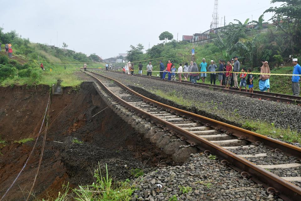 Sejumlah warga melihat kondisi tanah longsor di jalur rel Kereta Api (KA) Pangrango lintas Bogor-Sukabumi di Kelurahan Empang, Kota Bogor, Jawa Barat, Rabu (15/3/2023). Tanah longsor yang disebabkan curah hujan yang tinggi di wilayah Kota Bogor pada Selas