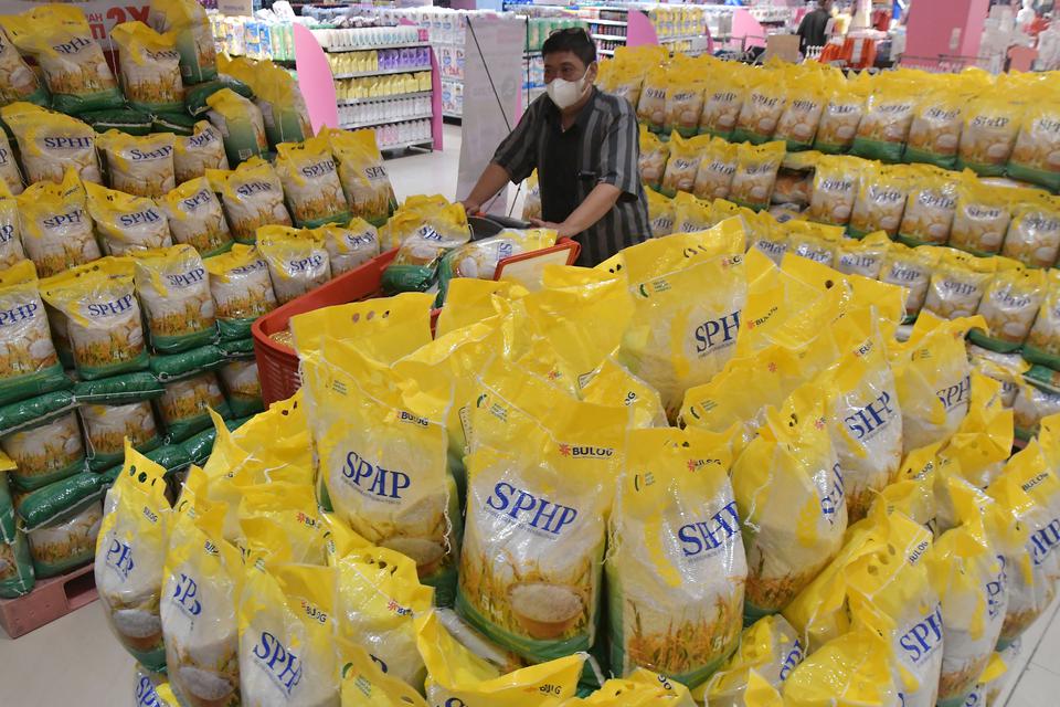 Pembeli melintas di samping beras Stabilisasi Pasokan dan Harga Pangan (SPHP) di Cempaka Putih, Jakarta, Rabu (15/3/2023). 