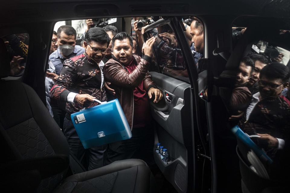 Menteri Komunikasi dan Informatika (Menkominfo) Johnny G Plate (tengah) masuk ke kendaraannya seusai menjalani pemeriksaan sebagai saksi di Kejaksaan Agung, Jakarta, Kamis (15/3/2023). 