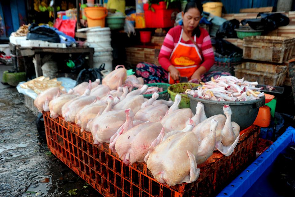 Penjual memotong ayam pesanan pelanggan di Pasar Palima Palembang, Sumatra selatan, Jumat (17/3/2023). 