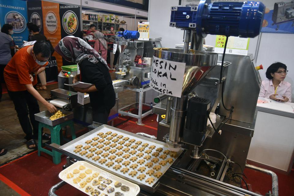 Pengunjung mengamati mesin pembuat kue kering saat pameran industri kuliner All Food Indonesia di ICE BSD, Tangerang, Banten, Minggu (19/3/2023). Pameran yang diikuti pelaku UMKM makanan dan minuman, bahan baku, peralatan dan teknologi terbaru di bidang i