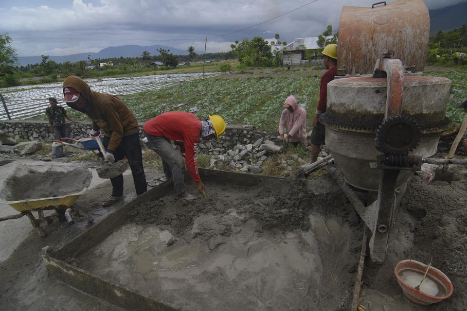 Sejumlah pekerja merampungkan pembuatan tembok dinding penahan jalan dalam program padat karya di Kabupaten Sigi, Sulawesi Tengah, Senin (27/3/2023). Kementerian Pekerjaan Umum dan Perumahan Rakyat (Kementerian PUPR) melanjutkan kembali pelaksanaan progra