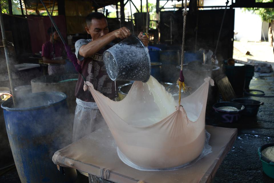 Pekerja menuangkan cairan kedelai saat proses produksi tahu di salah satu pabrik tahu, Desa Setui, Banda Aceh, Aceh, Rabu (29/3/2023). Menurut pengusaha tahu di daerah itu produksi tahu selama Ramadhan mengalami kenaikan sekitar 30 persen dibanding Ramadh