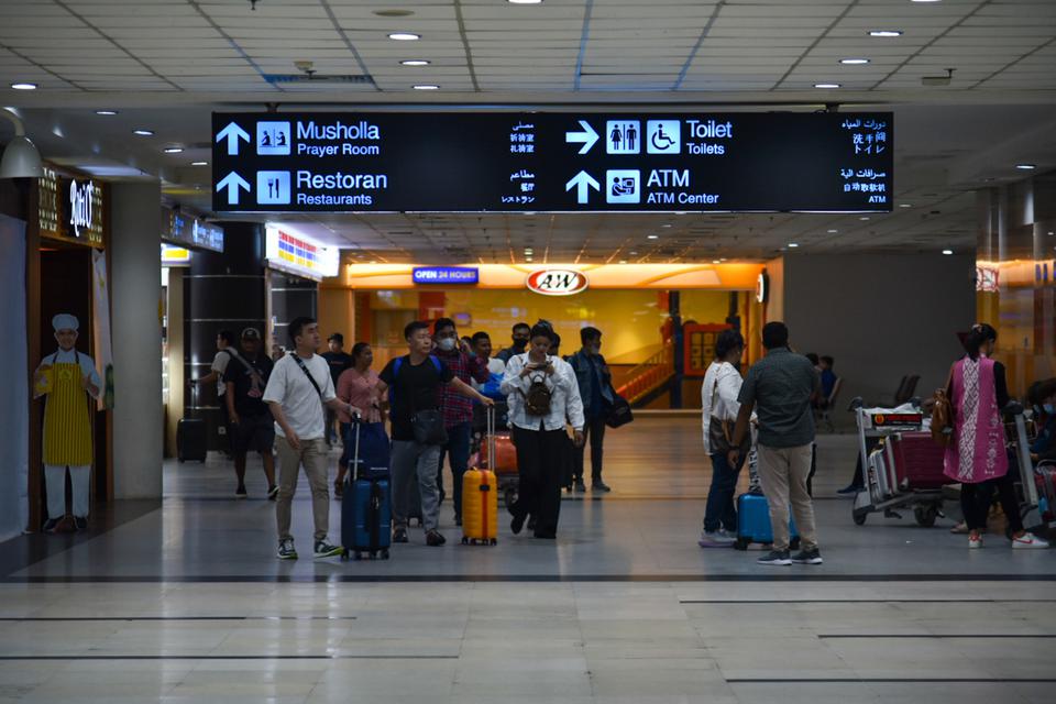 Sejumlah calon penumpang pesawat berjalan di area terminal keberangkatan Bandara Kualanamu, Deli Serdang, Sumatera Utara, Senin (3/4/2023). 