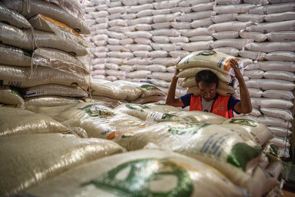 Pekerja memanggul karung berisi beras di gudang milik Perum Bulog Kantor Wilayah Sumsel-Babel di Palembang, Sumatera Selatan, Selasa (4/3/2023). Perum Bulog Kantor Wilayah Sumsel-Babel menyalurkan 6.171 ton beras medium untuk 617.121 orang penerima bantua