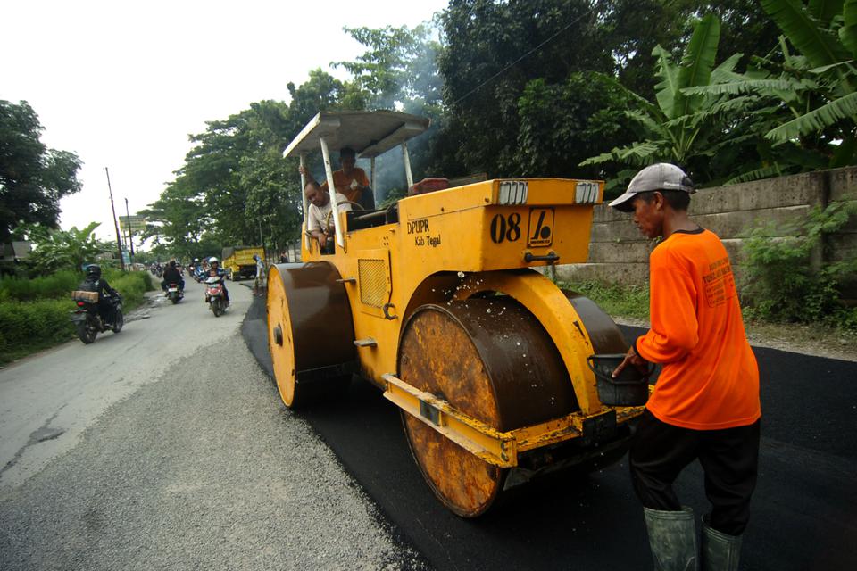 Pekerja memperbaiki jalan rusak di jalur alternatif untuk mudik Tegal-Puwokerto, Jawa Tengah, Selasa (4/4/2023).