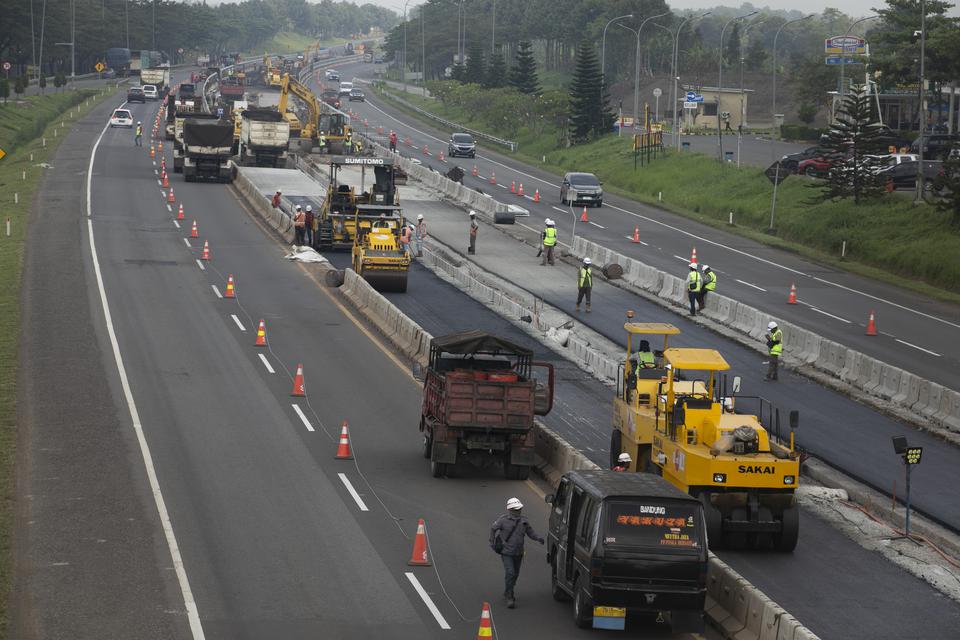 Pekerja menyelesaikan pembuatan lajur tiga di sekitar rest area KM 130 ruas tol Cipali, Indramayu, Jawa Barat, Rabu (5/4/2023). 