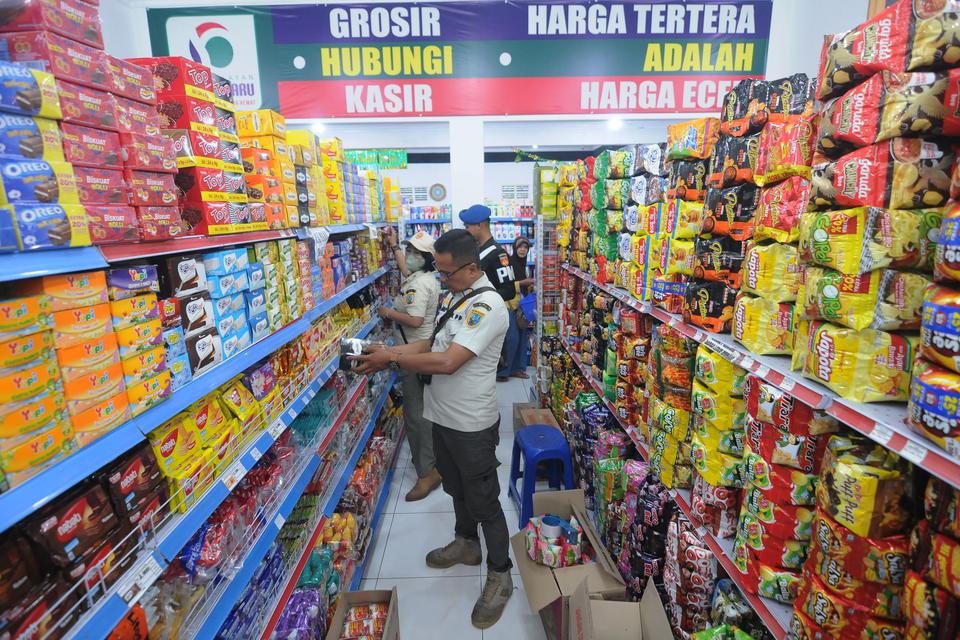 Petugas gabungan mengecek tanggal kedaluwarsa pada makanan saat razia di salah satu toko modern di Salatiga, Jawa Tengah, Rabu (5/4/2023). 