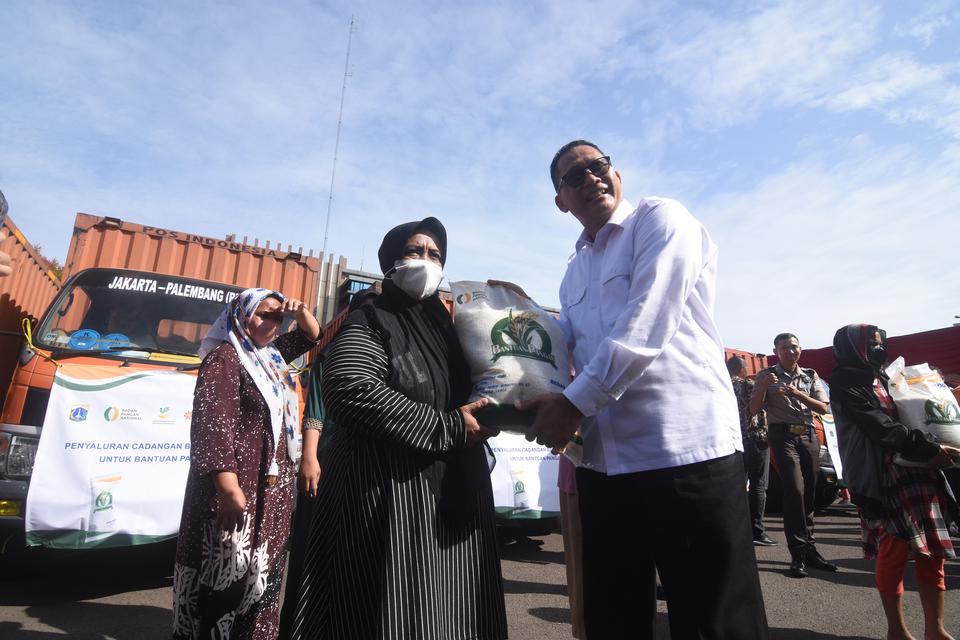 Direktur Utama Perum Bulog Budi Waseso (tengah) menyerahkan beras kepada peilan Keluarga Penerima Manfaat (KPM) saat acara Penyaluran Program Bantuan Pangan di Komplek Pergudangan Bulog Kelapa Gading, Jakarta, Kamis (6/4/2023).