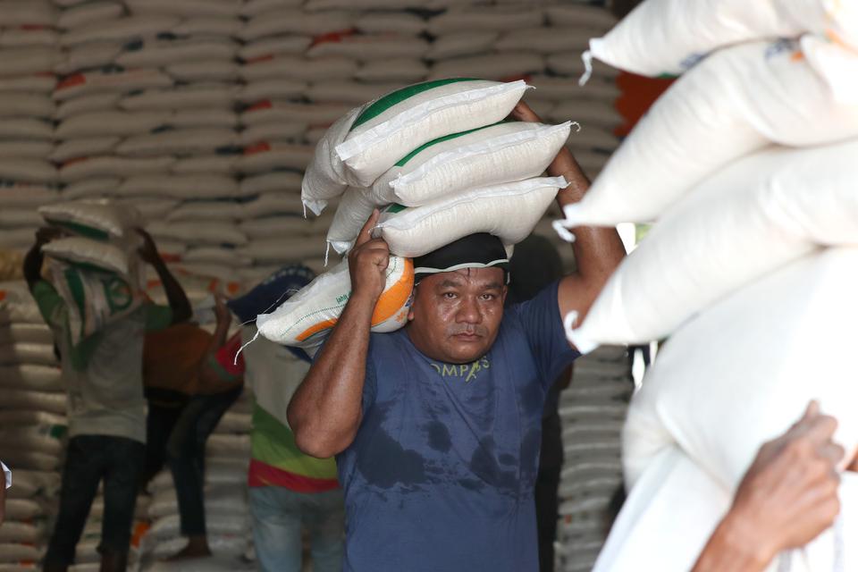 Pekerja mengangkut beras untuk didistribusikan di gudang Bulog, Aceh Besar, Aceh, Selasa (11/4/2023). Berdasarkan data Badan Pusat Staristik, panen raya pada Pebruari dan Maret 2023 di lahan seluas 2,9 juta hektare dengan rata-rata produksi sebanyak lima 