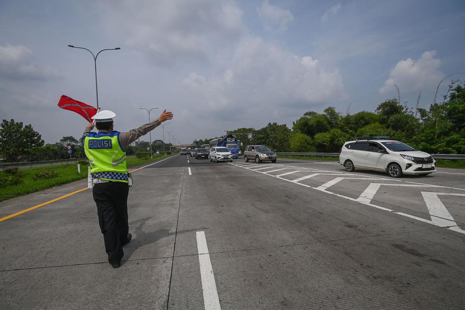 Polisi mengalihkan kendaraan bermotor dari arah Cirebon ke Jakarta untuk keluar melalui Gerbang Tol Subang saat sterilisasi ruas Tol Cipali dalam rangka penerapan kebijakan satu arah di Subang, Jawa Barat, Selasa (18/4/2023). Korlantas Polri merekayasa la