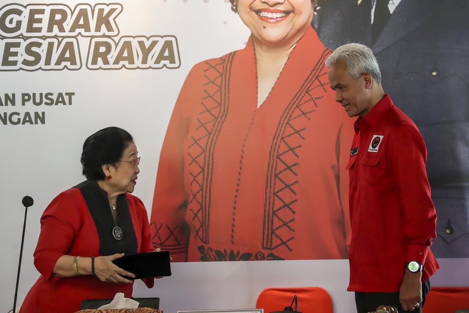Ketua Umum PDI Perjuangan Megawati Soekarnoputri (kiri) bersiap menyematkan peci kepada calon Presiden 2024 yang diajukan PDI Perjuangan Ganjar Pranowo (kanan) di Istana Batu Tulis, Bogor, Jawa Barat, Jumat (21/4/2023). 