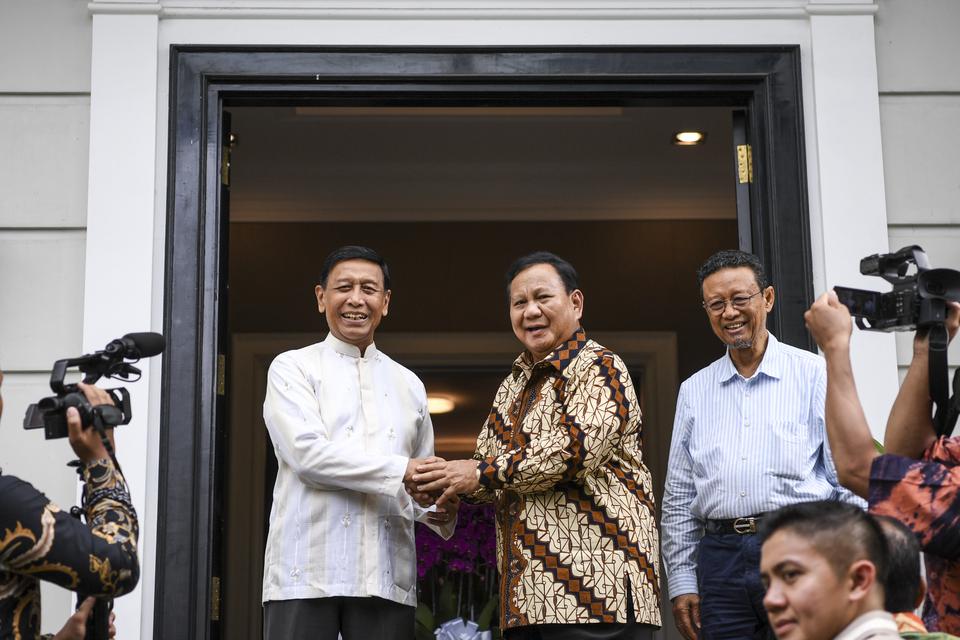 Menhan Prabowo Subianto (tengah) berjabat tangan dengan Ketua Dewan Pertimbangan Presiden Wiranto (kiri) saat tiba di kediaman Wiranto, di Bangka Raya, Jakarta, Selasa (25/4/2023). Kunjungan Prabowo Subianto tersebut merupakan rangkaian dari silaturahmi l