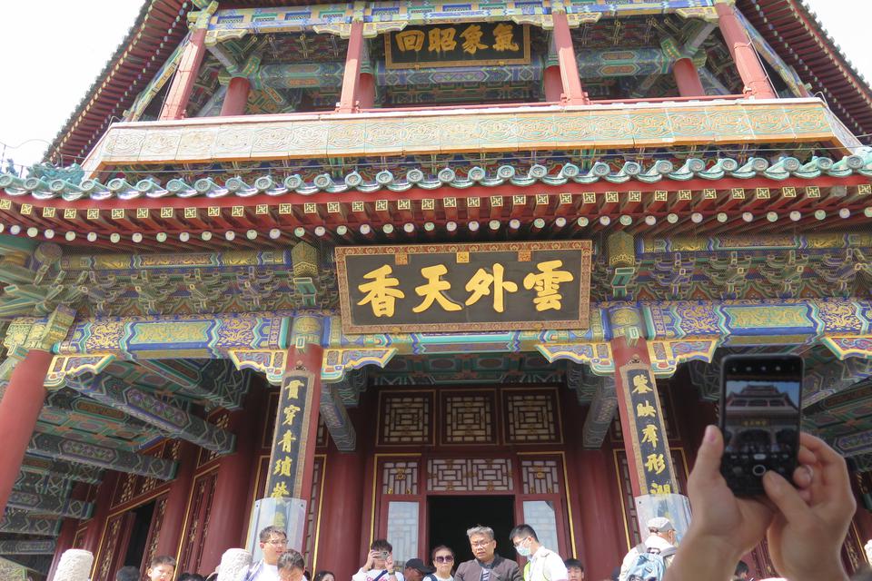 Seorang wisatawan memotret menara Buddha, bangunan tertinggi di kompleks Istana Musim Panas, Beijing, China, Senin (1/5/2023). Warisan budaya dunia yang dibangun oleh Raja Qianlong dari Dinasti Jin pada tahun 1749 Masehi itu menjadi objek wisata favorit s