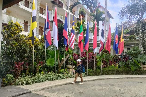 Seorang wartawan melewati bendera negara-negara anggota ASEAN di lokasi media center KTT ASEAN 2023 di hotel Bintang Flores, Labuan Bajo, Nusa Tenggara Timur, Selasa (2/5/2023).