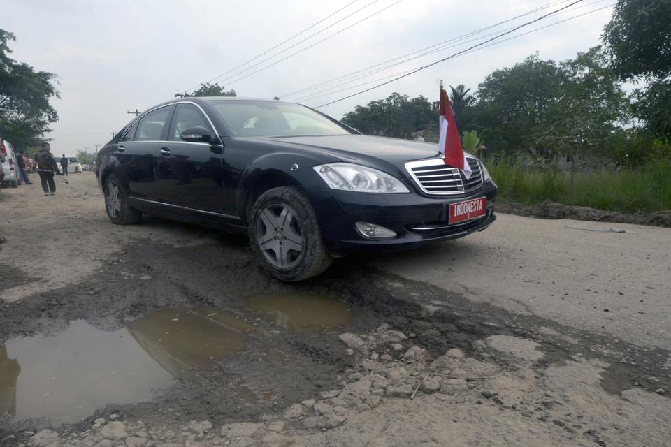 Mobil dinas Presiden Joko Widodo melintas di jalan yang rusak saat meninjau jalan rusak di Kampung Rama Nirwana, Seputih raman, Lampung Tengah, Lampung, Jumat (5/5/2023). Presiden Jokowi mengucurkan dana Rp800 miliar untuk memperbaiki jalan rusak di Provi