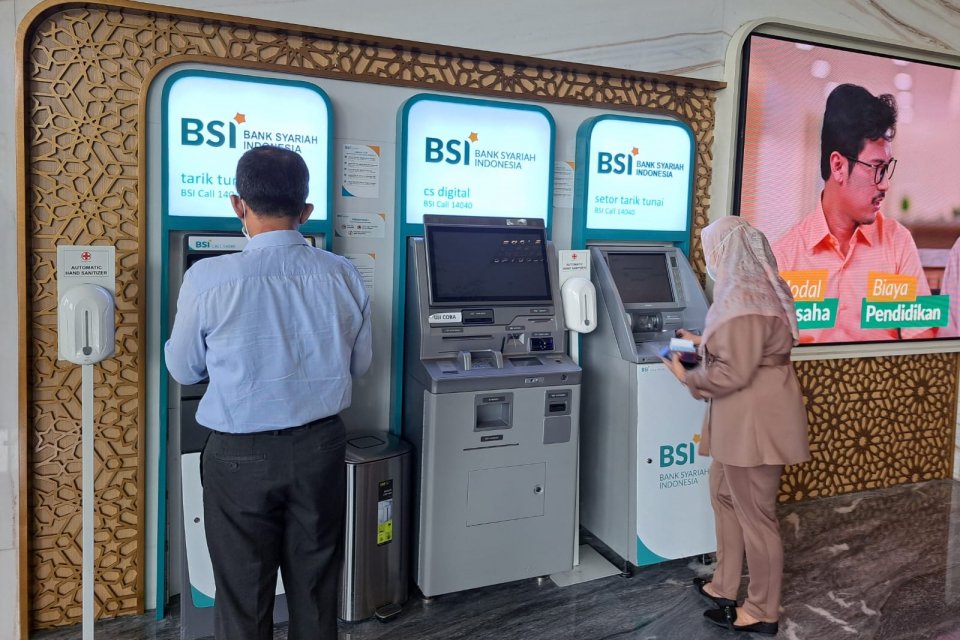 Pelanggan PT Bank Syariah Indonesia (BSI) mengunjungi mesin ATM.