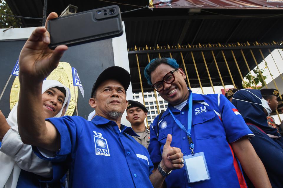 Selebritas yang juga bakal calon legislatif Partai Amanat Nasional (PAN) Surya Utama alias Uya Kuya (kanan) berswafoto dengan kader partai lainnya usai pengajuan berkas bakal calon anggota DPR di Gedung KPU, Jakarta, Jumat (12/5/2023). 