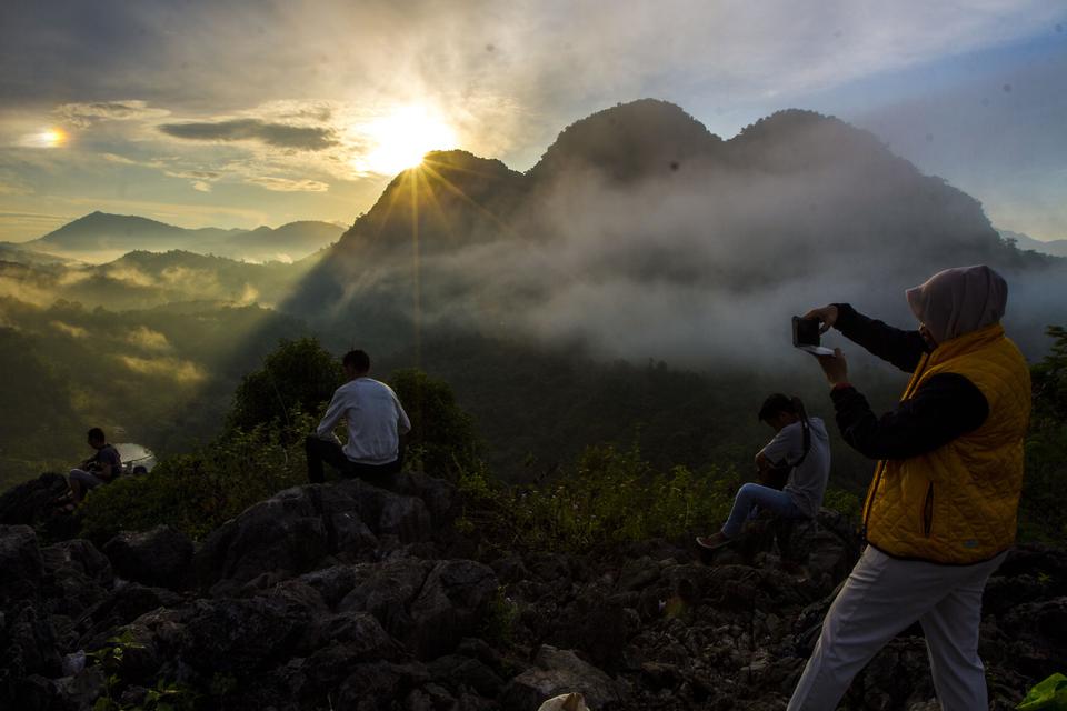 Pengunjung mengambil gambar di situs Geopark Meratus puncak bukit Langara, Kecamatan Loksado, Kabupaten Hulu Sungai Selatan, Kalimantan Selatan, Sabtu (20/5/2023). 