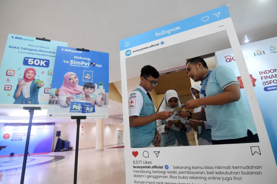 Pegawai memberikan edukasi literasi keuangan kepada pelajar nasabah tabungan pelajar BCA Syariah pada acara Indonesia Sharia Financial Olympiad (ISFO) 2023 di Jakarta, Senin (22/5/2023). Kegiatan tersebut diselenggarakan inisiatif OJK dan Lembaga Keuagan 